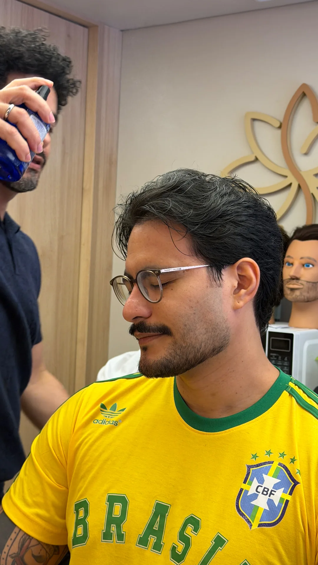 Profissional finalizando o cabelo de um cliente na Identidade Studio